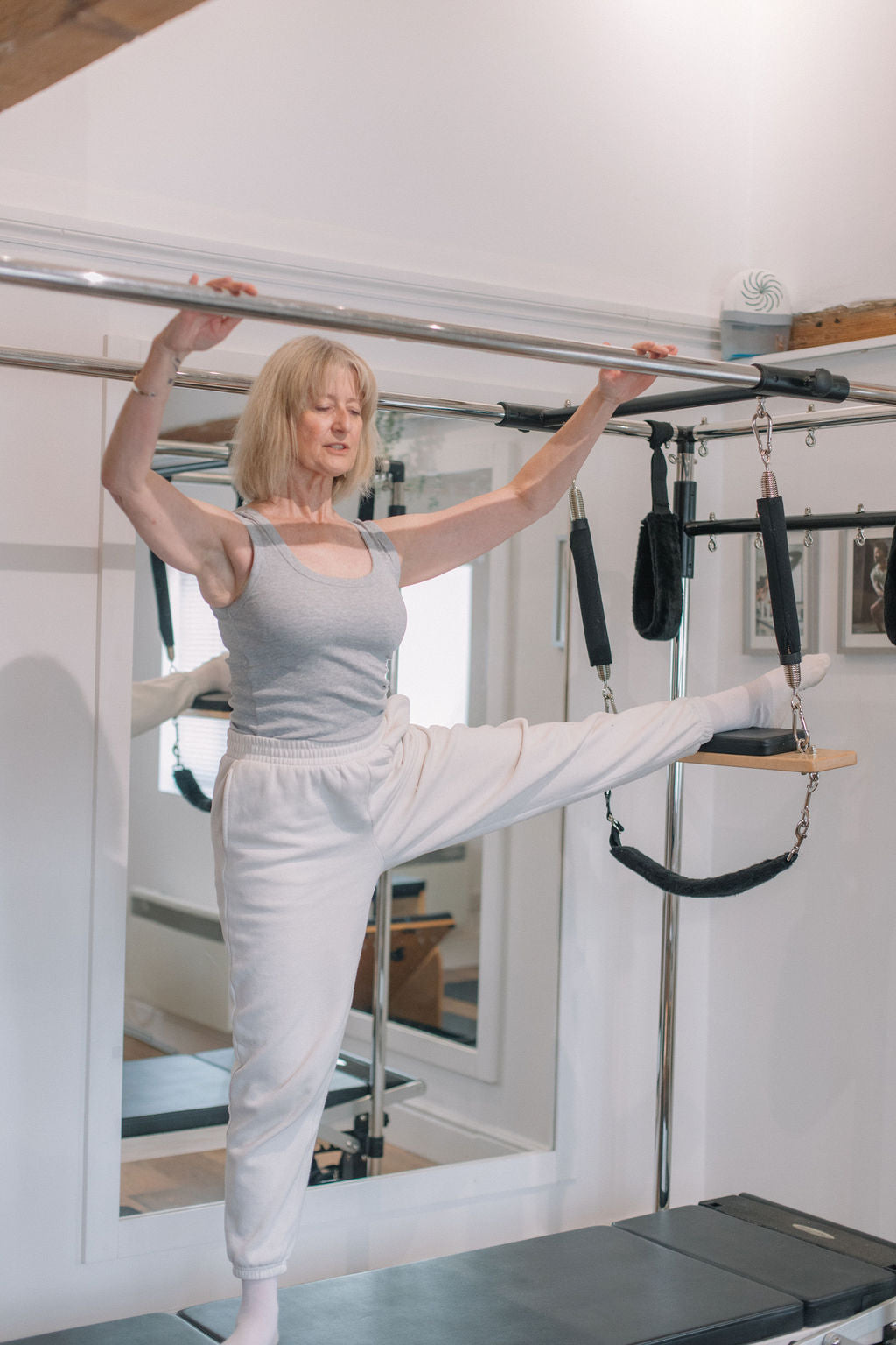 Client performing a standing leg lift at the Cadillac
