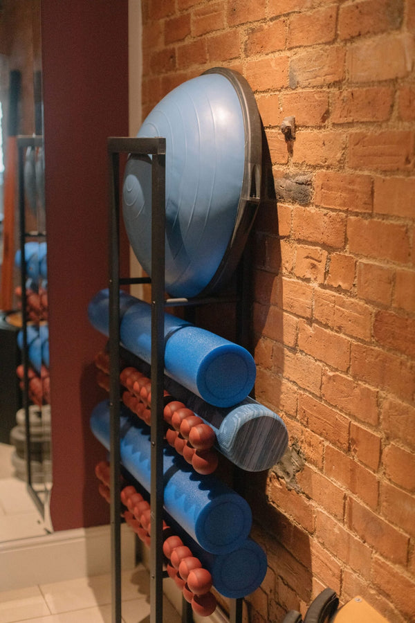 Studio storage rack with foam rollers and Pilates props