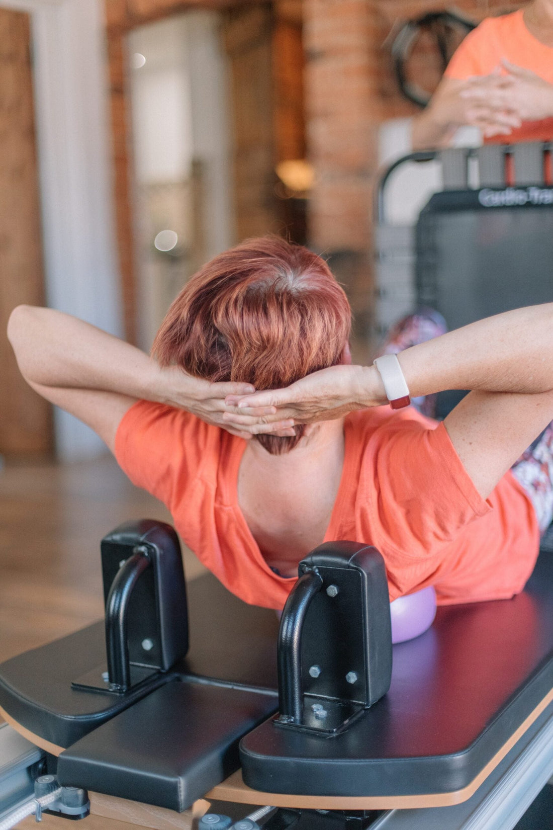 Client doing head-supported abdominal curls on a reformer