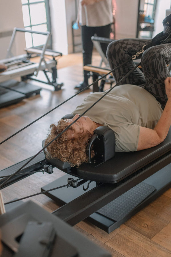 Client's head resting against the reformer shoulder blocks