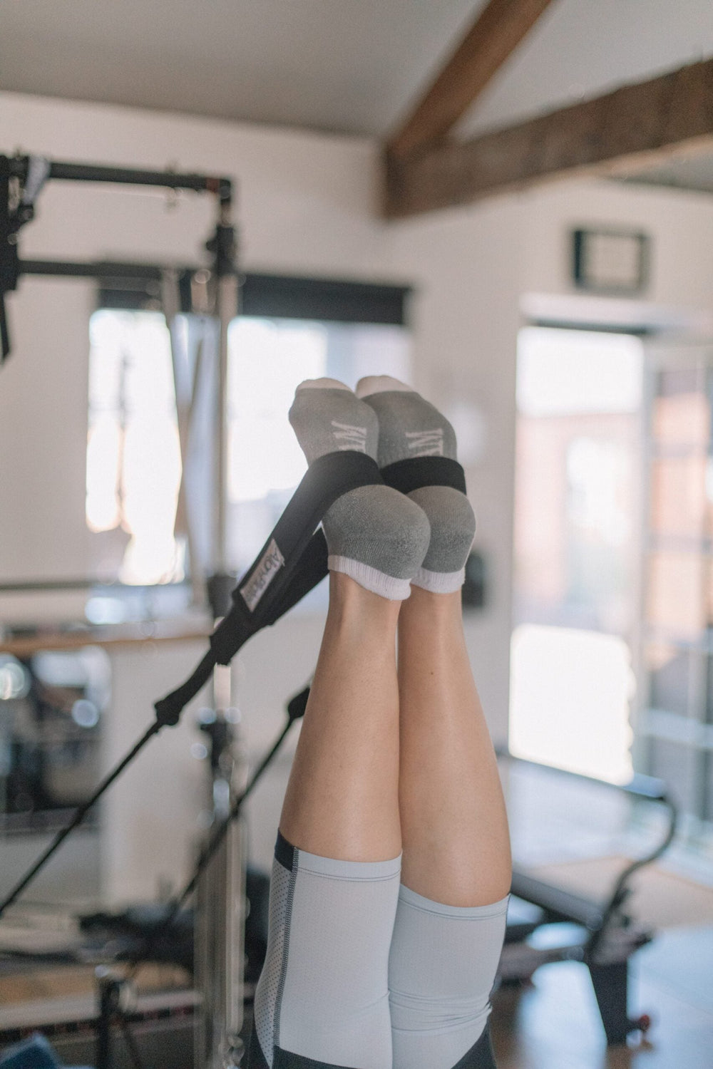 Feet in the reformer straps during a leg exercise