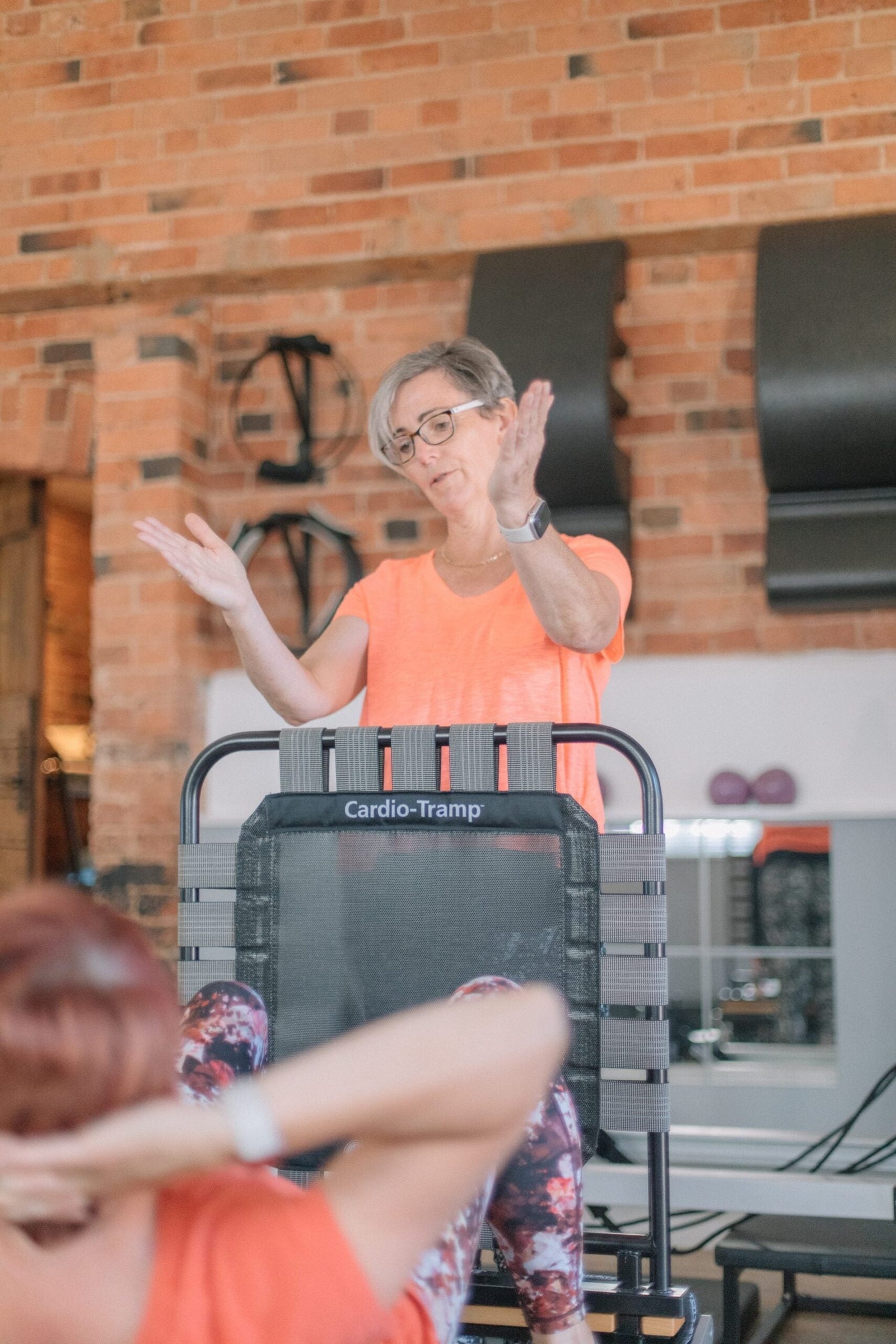 Instructor leading a small reformer and Cardio-Tramp class, showing a regular weekly Pilates routine