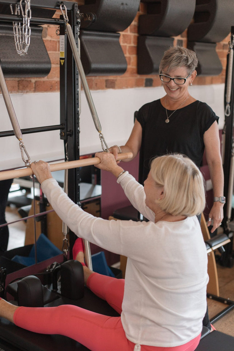 Clients working with the roll-up bar at the tower, upright resistance work of the kind used when training with low bone density