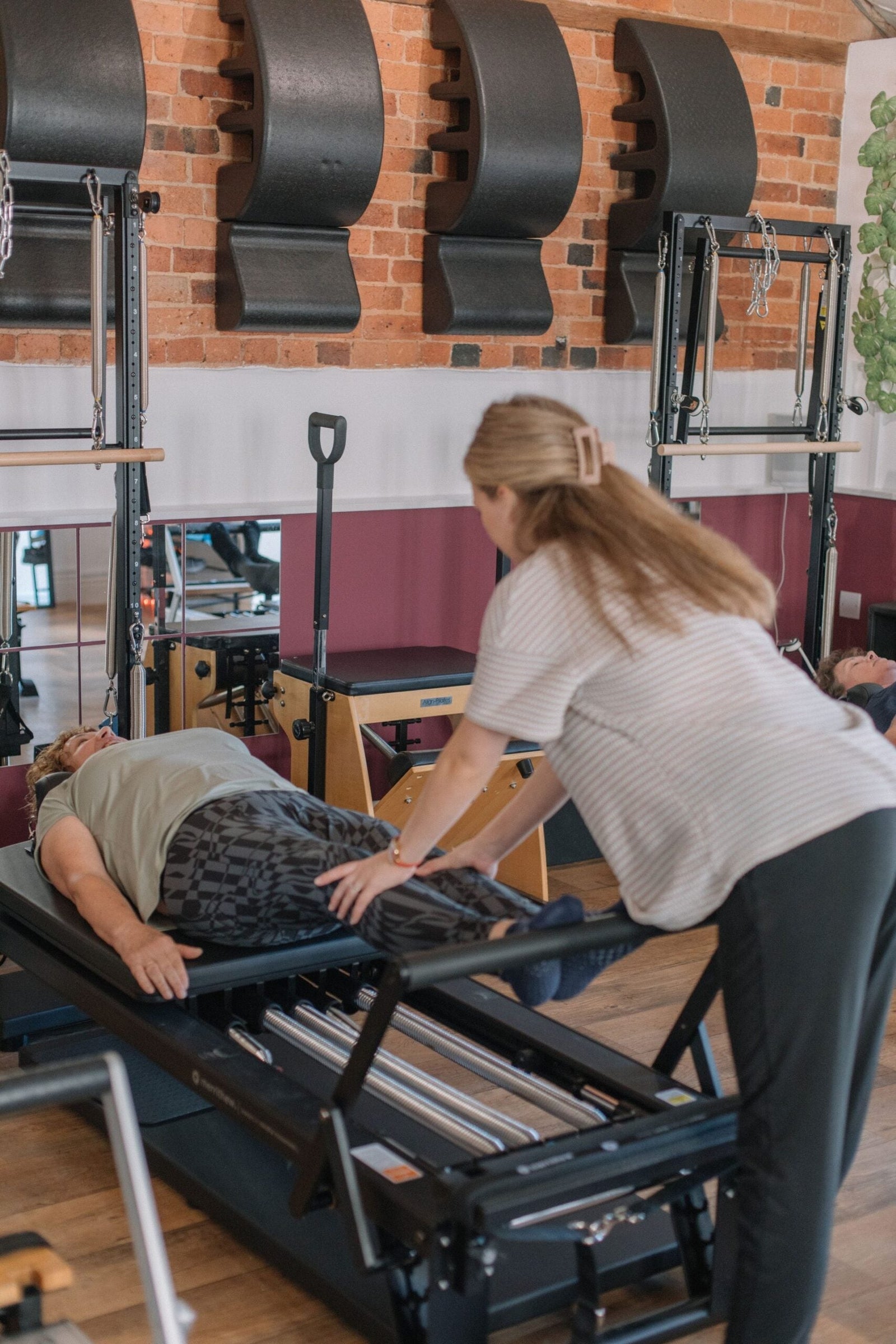 Instructor giving precise hands-on guidance, the kind of feedback that helps hypermobile clients find control