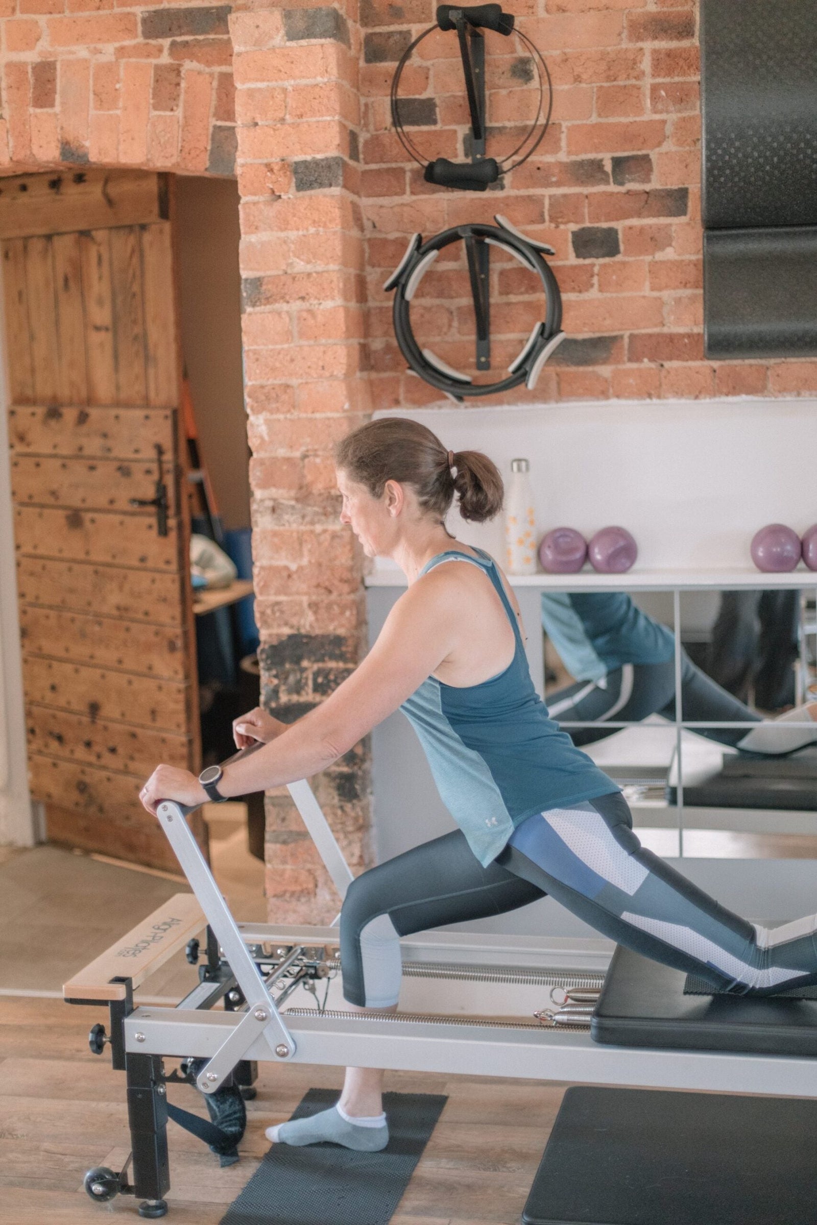 Client in a deep lunge on the reformer, opening the hip flexors that cycling keeps shortened