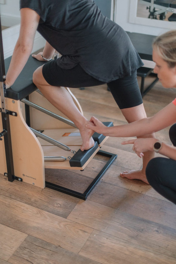 Close-up of a foot on a wooden Pilates foot corrector