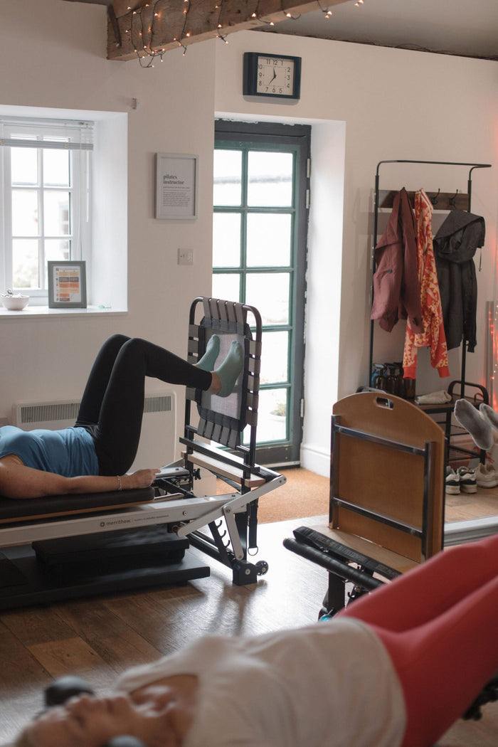 Instructor supervising a small reformer class