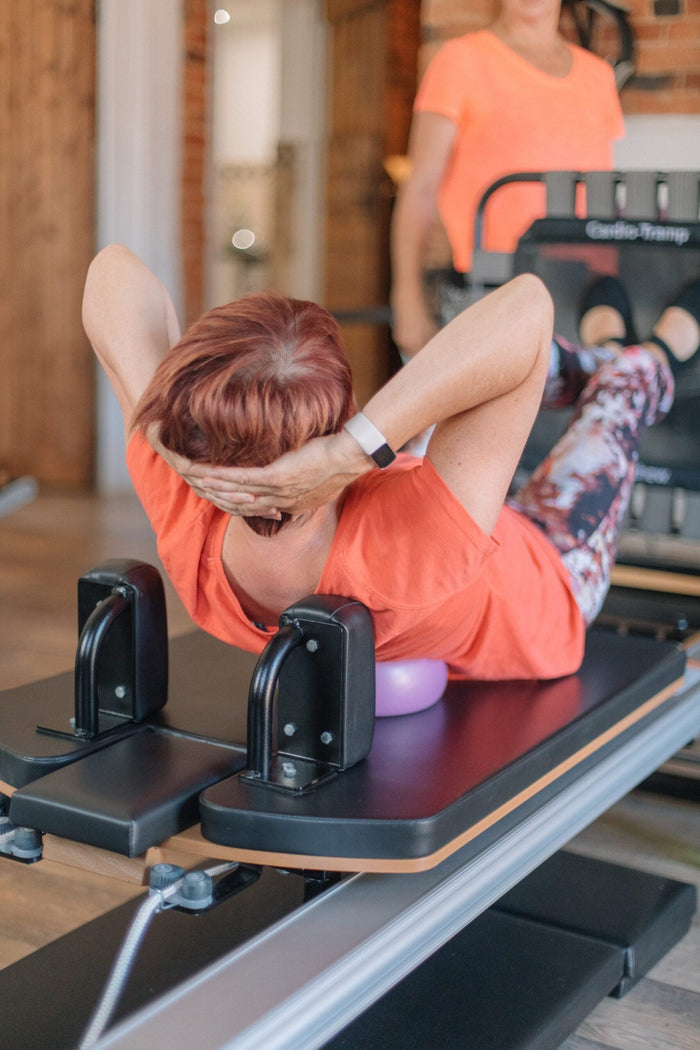 Abdominal curls with a soft ball on a reformer